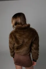 Campera corta marrón de pelo sintético con forro interior y puños de cuero sintético.