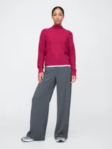 Sweater de punto trenzado color celeste con cuello alto.