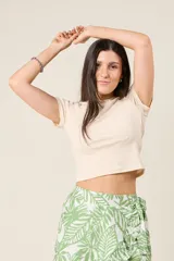 Remera corta color beige de corte ajustado y mangas cortas.