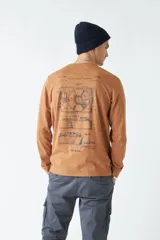 Remera de manga larga color marrón con estampado en el pecho.