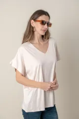 Remera holgada color beige, de escote en V y mangas cortas.