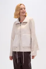 Campera color beige de corte recto, con cuello de piel sintética, cierre frontal con cremallera, bolsillos laterales con cremallera y cordón ajustable en el ruedo.