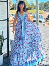Vestido largo con estampado abstracto en tonos celeste, azul y violeta, con breteles finos y escote en V. Presenta volados en el ruedo y detalle de cordón ajustable en el busto.