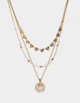 Collar corto dorado de tres capas: una con mostacillas doradas, otra con dijes de corazones y otra con dije circular rosa.
