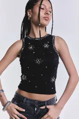 Musculosa negra de punto acanalado con cuello redondo y apliques de strass plateados en forma de flores y tachas alrededor del cuello y las sisas.