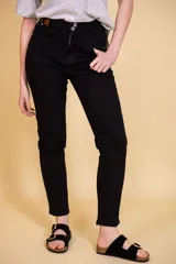 Pantalón jean negro de tiro alto, con cinco bolsillos, confeccionado en tela con elastano. Tiene cierre frontal con doble botón y cierre metálico, y detalle de cuero en la parte delantera de la pretina.