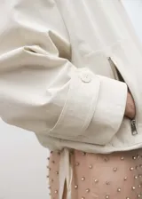 Campera blanca con cierre frontal y cuello marrón de seda.
