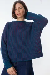 Sweater de punto grueso a rayas verticales en color azul petróleo y borgoña, de corte holgado y mangas largas.