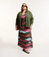 Campera plus size color verde militar, modelo oversized, confeccionada en sarga texturizada. Cuenta con cuello tradicional, cierre abotonado, dos bolsillos delanteros y puños abotonados.