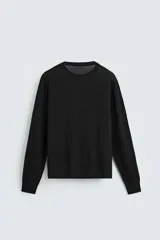 Jersey negro de lana con acabado mercerizado, corte relaxed fit, cuello redondo y mangas largas con terminaciones en rib.