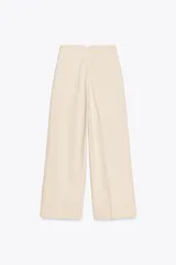 Pantalón color crema de lino, de tiro alto, corte recto y bolsillos delanteros.