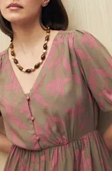 Vestido corto con estampado paisley en tonos azul marino, rosa y blanco. Tiene escote en V, mangas cortas abullonadas con puños elásticos, corte en la cintura y falda con vuelo. Incluye cinturón marrón.