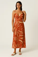 Vestido midi de viscosa con estampado de hojas tropicales en tonos terracota y beige. Presenta escote en V con nudo central fruncido y tirantes finos.