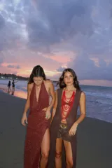 Falda larga tejida color vino tinto con brillo dorado, de corte ajustado y abertura lateral en la pierna.