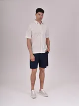 Camisa verde de manga corta con cuello clásico y cierre frontal con botones.