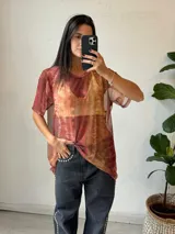 Remera de microtul con estampado abstracto en tonos marrones, naranjas y rojos.