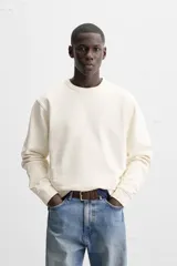 Sudadera negra de corte holgado, cuello redondo y mangas largas con puños acanalados.