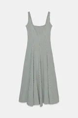 Vestido midi de tirantes con escote cuadrado y falda amplia con godets, confeccionado en tela con estampado de cuadros vichy en blanco y negro.