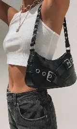 Cartera bandolera negra de cuero sintético con correa ajustable y detalles de hebillas plateadas.