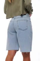 Bermuda de jean celeste con ruedo desflecado.