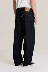 Pantalón de jean azul oscuro, corte amplio, con bolsillos delanteros y traseros.