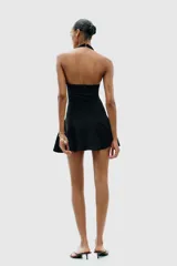 Vestido corto blanco de tejido de punto elástico, con cuello halter, escote corazón y cierre con botones en el cuello.