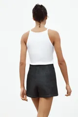 Minifalda pantalón de tiro alto confeccionada en denim azul oscuro. Presenta una abertura delantera y cierre lateral con cremallera oculta.