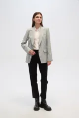 Blazer gris claro con rayas verticales finas, cuello con solapa, cierre con dos botones, bolsillos laterales con solapa y corte holgado.