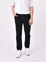 Pantalón jogger negro con cintura elástica ajustable con cordón y tobillos ajustados.