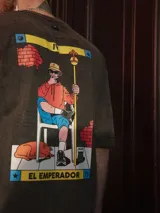 Remera negra con efecto nevado, de manga corta y cuello redondo. Estampado en la espalda con la carta del tarot 'El Emperador'.