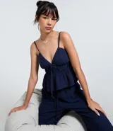 Pantalón femenino azul marino, estilo pijama, confeccionado en algodón texturizado. Posee cintura elástica con cordón para ajuste y bolsillos laterales.