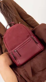 Mochila color tostado combinada con nobuck, bolsillo amplio adelante con broche y cierre, bolsillos en los costados, asas regulables y bolsillos internos cómodos.