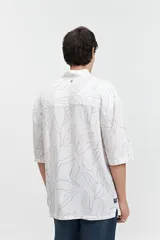 Camisa oversize de manga corta con estampado abstracto en tonos beige y blanco.