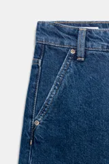 Shorts blancos de tiro medio con trabillas, bolsillos laterales y traseros. Cierre frontal con cremallera y botón metálico.