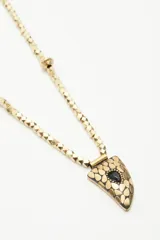 Collar regulable con cadena de piezas metálicas facetadas y un dije en forma de cuerno con piedra incrustada, de estilo bohemio.