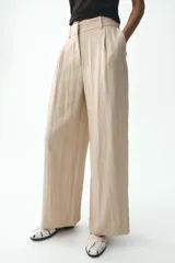 Pantalón negro de tiro alto con bolsillos delanteros, pinzas y corte ancho.