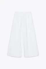 Pantalón culotte blanco de tiro medio con cintura elástica y bolsillos laterales ocultos en la costura.