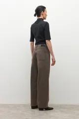 Pantalón de jean estilo barrel, color marrón oscuro con efecto desgastado. Presenta un calce holgado y tiro alto.