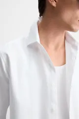 Camisa blanca de algodón, corte slim fit, cuello italiano, manga larga con puños abotonados y cierre frontal con botones.