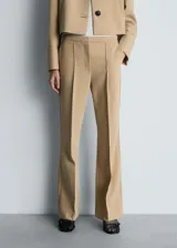 Pantalón de vestir color beige, de tiro medio y corte acampanado.