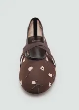 Zapato tipo bailarina color rojo con tejido de malla bordado con flores y tiras cruzadas.
