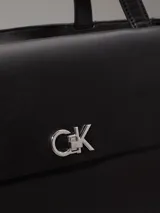 Cartera tote Calvin Klein color negro, confeccionada en piel sintética, con doble asa de hombro, cierre superior con cremallera, bolsillo externo con cierre giratorio y logo CK plateado.