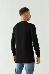 Sweater mostaza de punto con cuello redondo, mangas largas y logo bordado en el pecho. Corte slim fit.