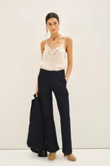 Pantalón sastrero de denim azul oscuro, corte recto, con costuras a contratono, cierre metálico, gancho sastrero y botón en la cintura.