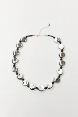Collar corto con cordón negro y cuentas irregulares plateadas.