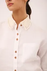 Camisa blanca de lino con cuello clásico y puños con detalle de crochet.