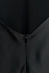 Vestido midi negro de satén con escote en pico, tirantes finos ajustables y espalda cruzada. Cierre trasero con cremallera oculta.
