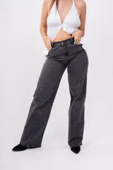 Pantalón de jean negro de corte wide leg con estampa de pequeñas estrellas blancas.