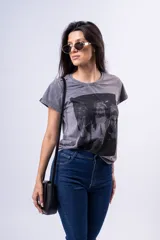 Remera gris con efecto acid wash y estampa frontal con tres figuras femeninas.