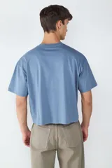 Camiseta celeste de corte amplio y cuello redondo, confeccionada en 100% algodón.